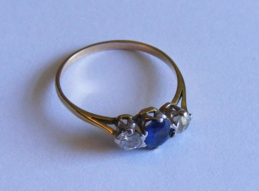 "A good quality yellow metal three-stone Ring the central blue stone flanked by two good Diamonds,