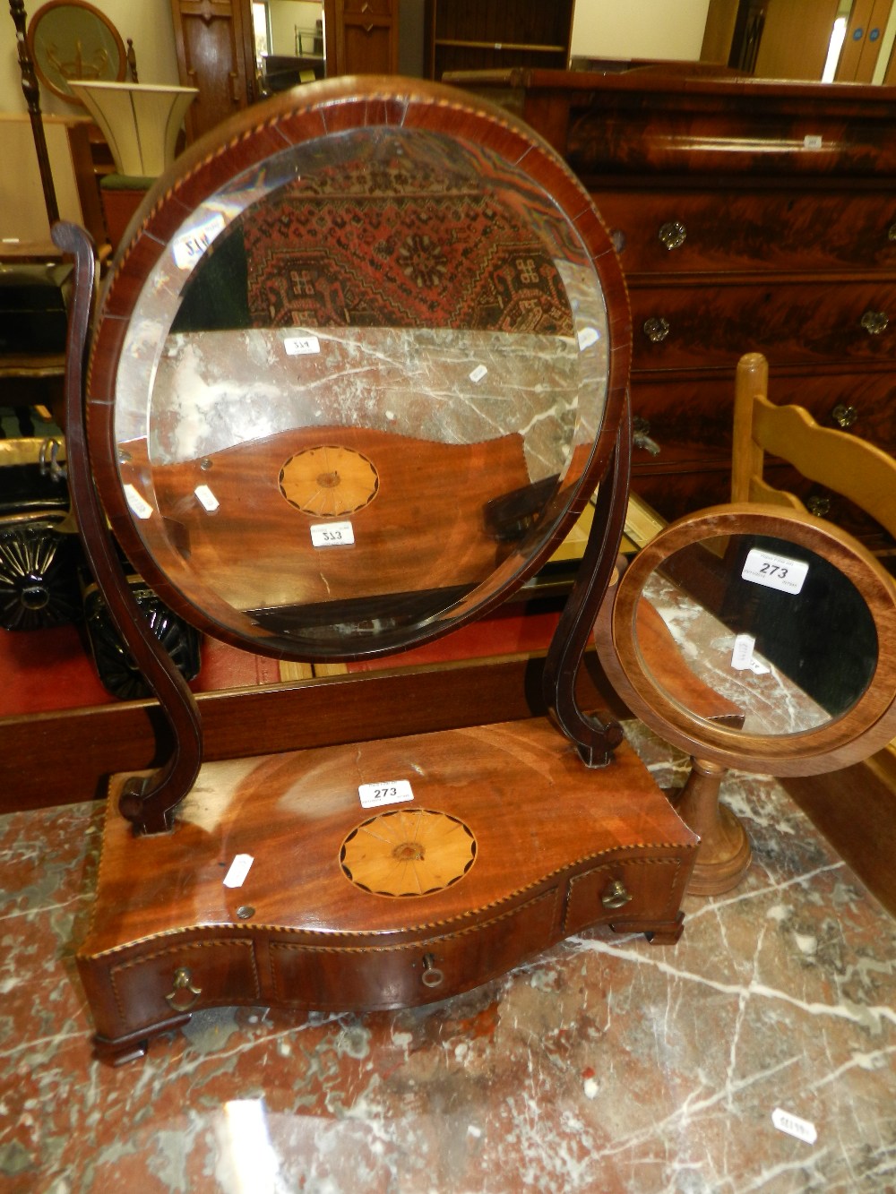 A George III mahogany serpentine swivel toilet mirror along with a 19th century circular swivel