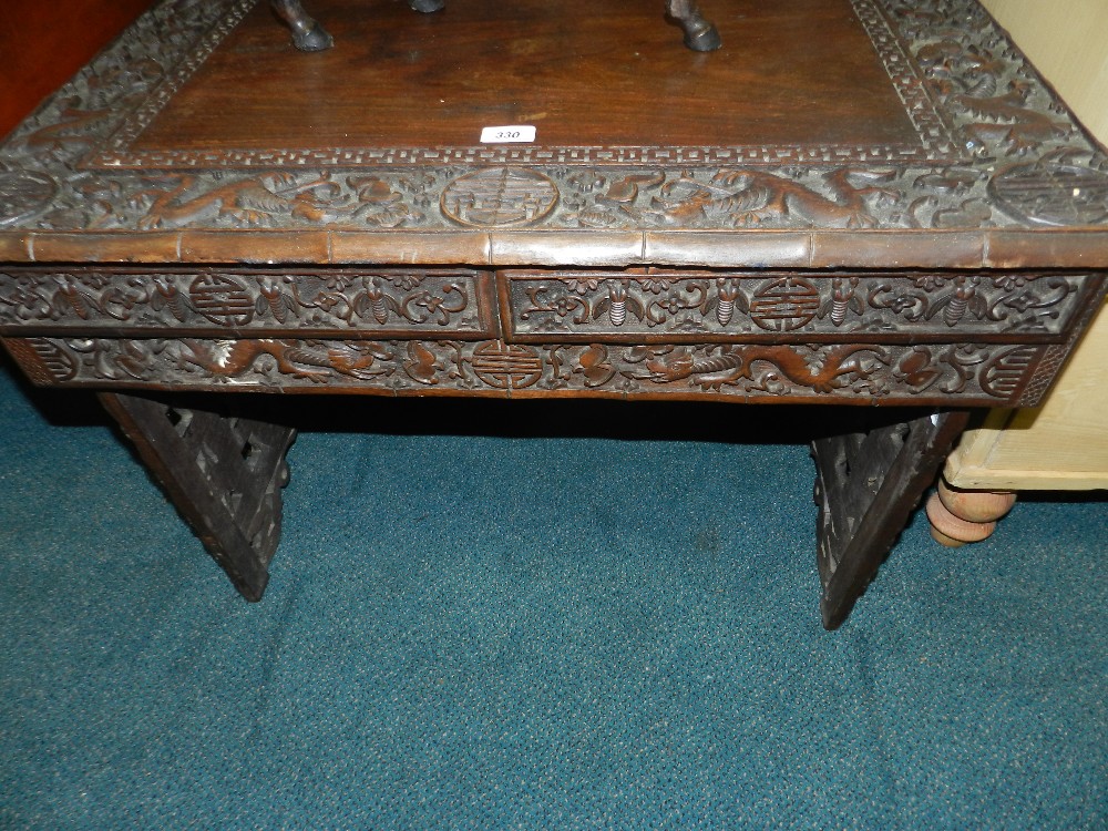A Chinese hardwood folding table, 20th century, of rectangular form with carved dragon and shou