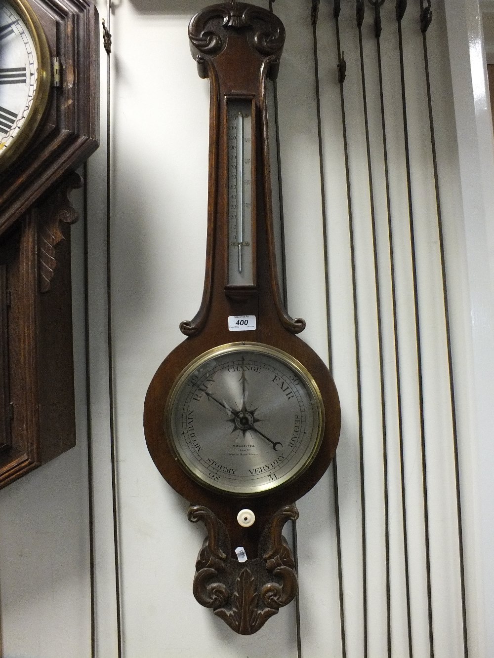 An oak cased wheel barometer with a thermometer above.