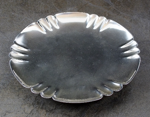 A Goldsmiths & Silversmiths Co Ltd silver platter, London 1946, of plain polished lobed circular