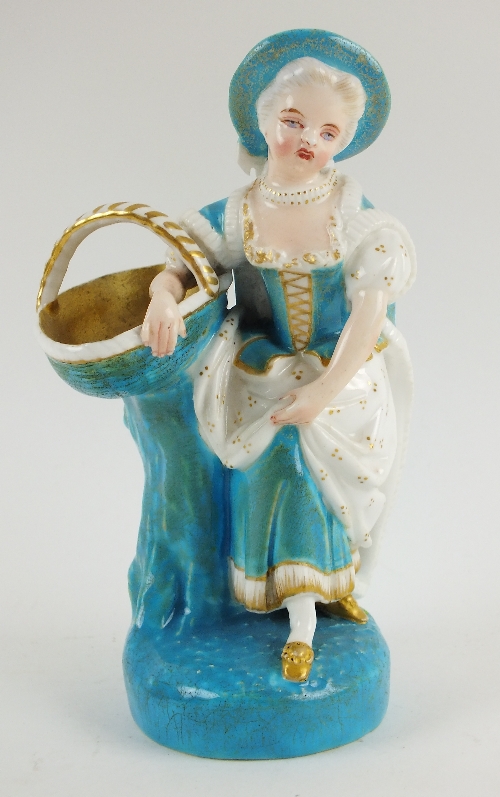 A Royal Worcester figure, modelled as a lady in blue and white gown, holding a basket, highlighted