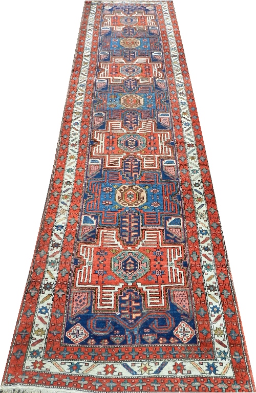 A 20th century Caucasian design runner, the stylised centre within a triple border, 114cm wide,