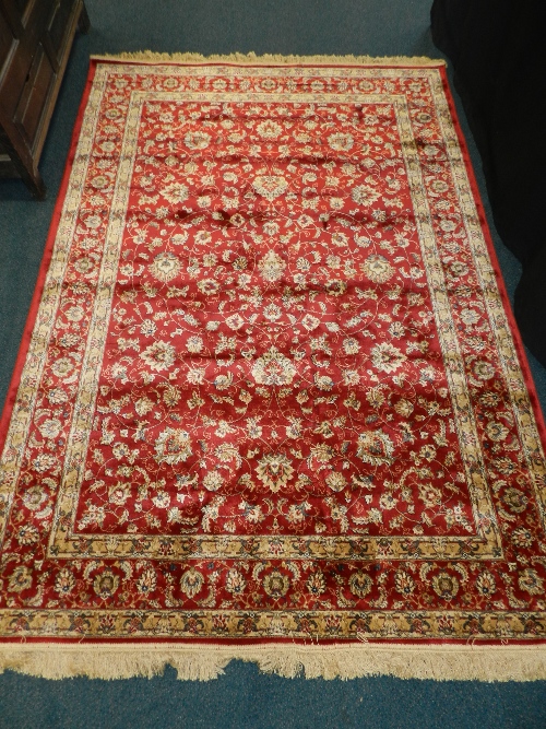 A Kashmir rug profusely decorated with flowers against a red ground