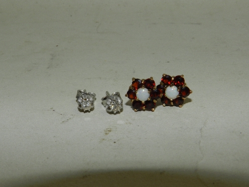 A pair of diamond set stud earrings together with a pair of pearl and garnet set flower head