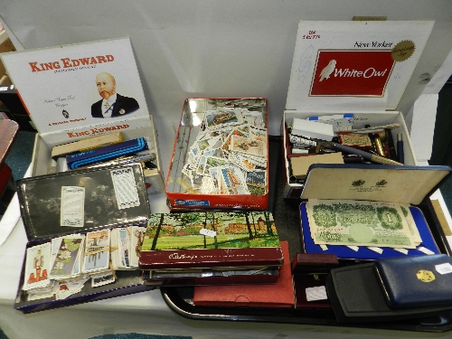 A quantity of pens and accessories; an assortment of coins, cufflinks, silver lighters, trade cards,