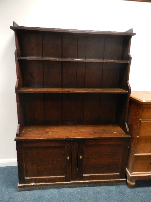 A Victorian stained pine waterfall bookcase with two cupboard doors on plinth base