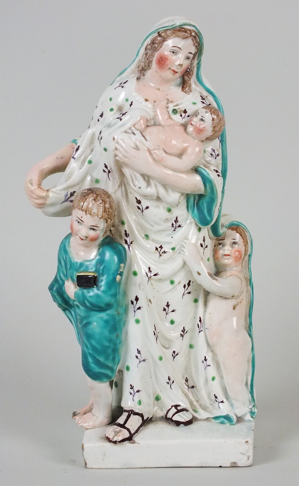 A Staffordshire pearlware model of Charity, early 19th century, her robes and the children beside