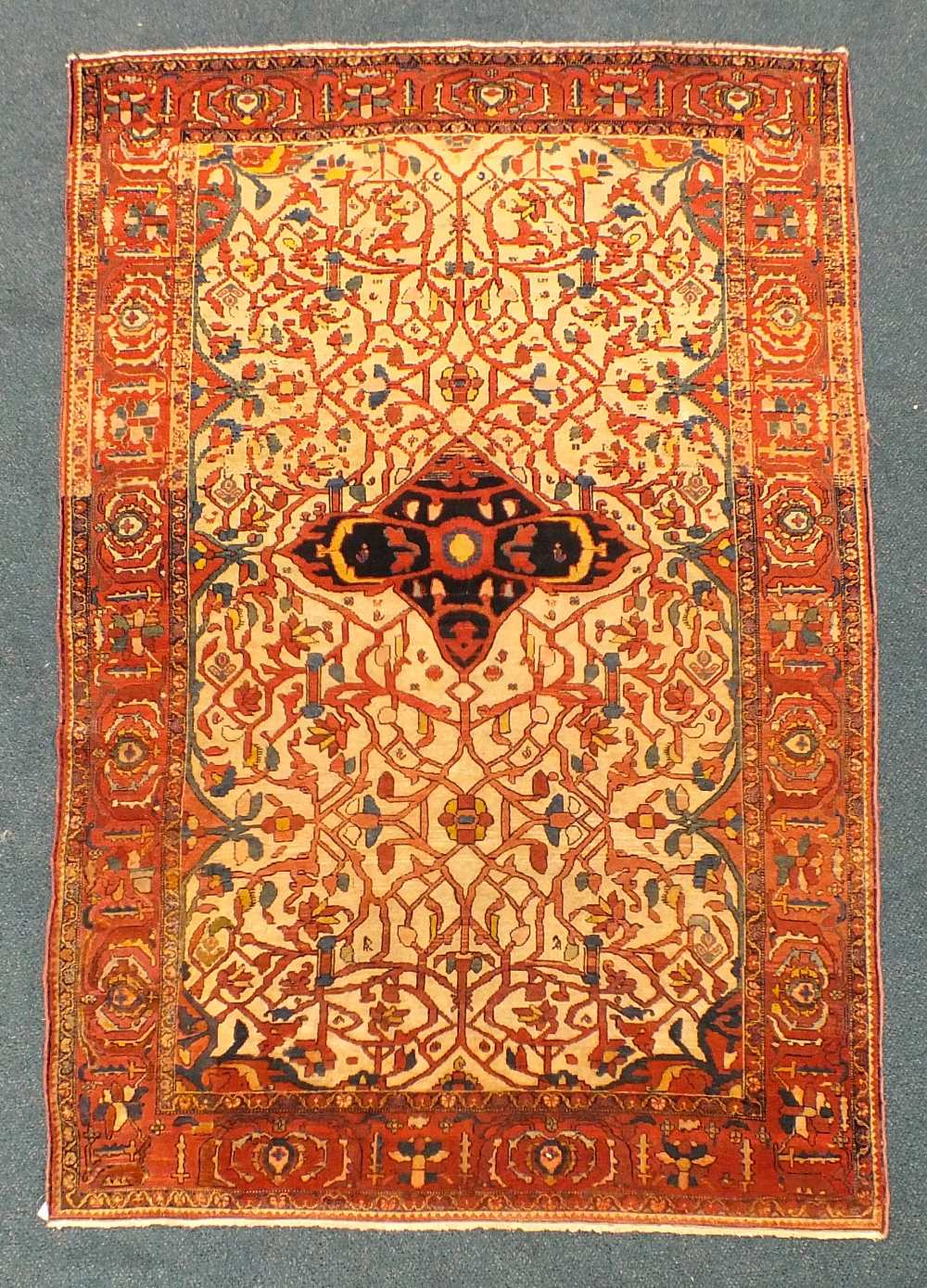 A Saroukh Feraghan Rug, West Persia,
the ivory lattice field of scrolling angular vines centred by a