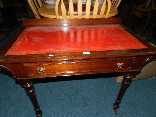 A late Victorian walnut writing table with drawer on turned and fluted legs