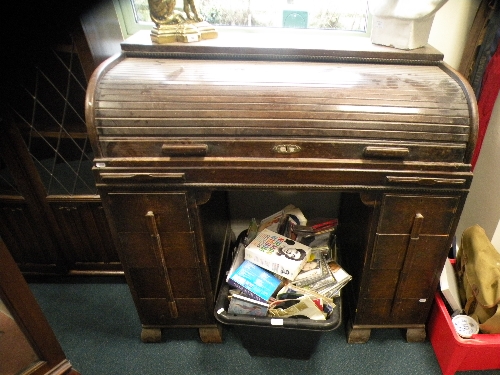 A 1940s oak roll top desk with six drawers on block feet