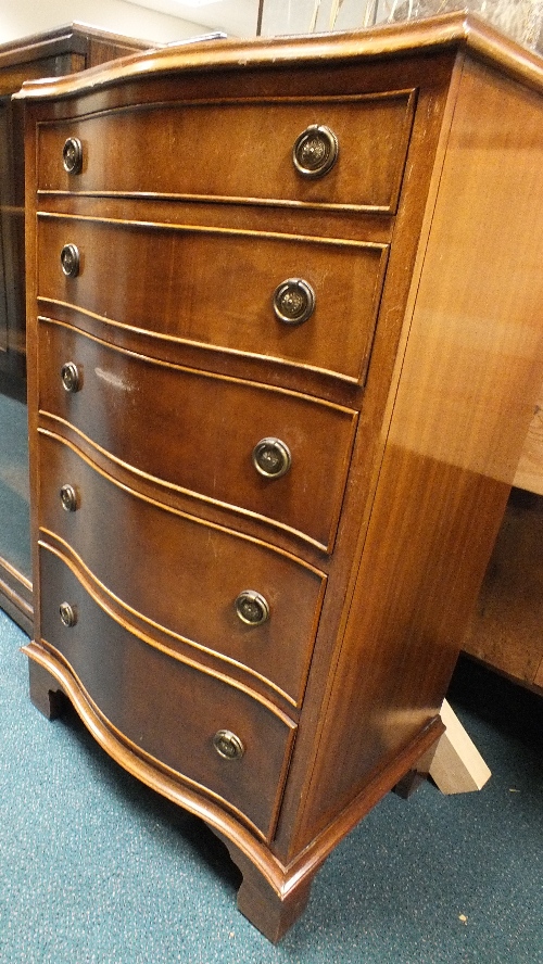 A reproduction mahogany serpentine chest of five graduated drawers on bracket feet