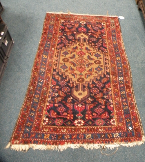 A Caucasian rug decorated with a central ivory field within a blue surround within border stripes