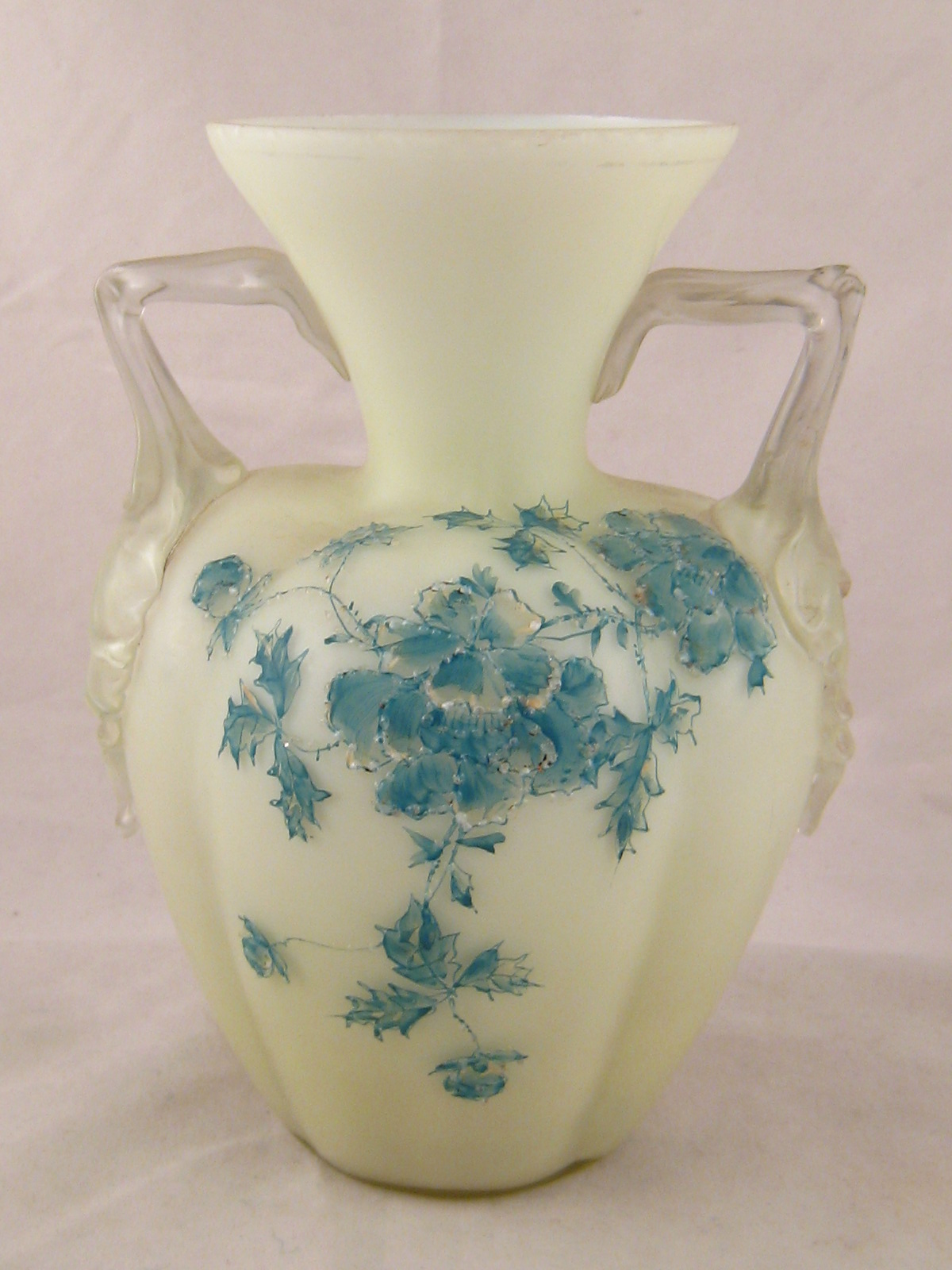 A two handled glass vase, the lobed body with apple green overlay on milk glass,  hand decorated