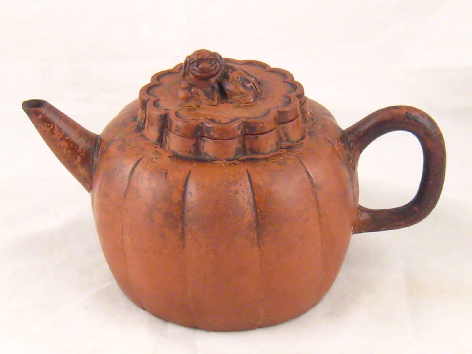 An 18th. c. Chinese red bodied melon shaped teapot with dog of Fo finial lid. 19cm. across.