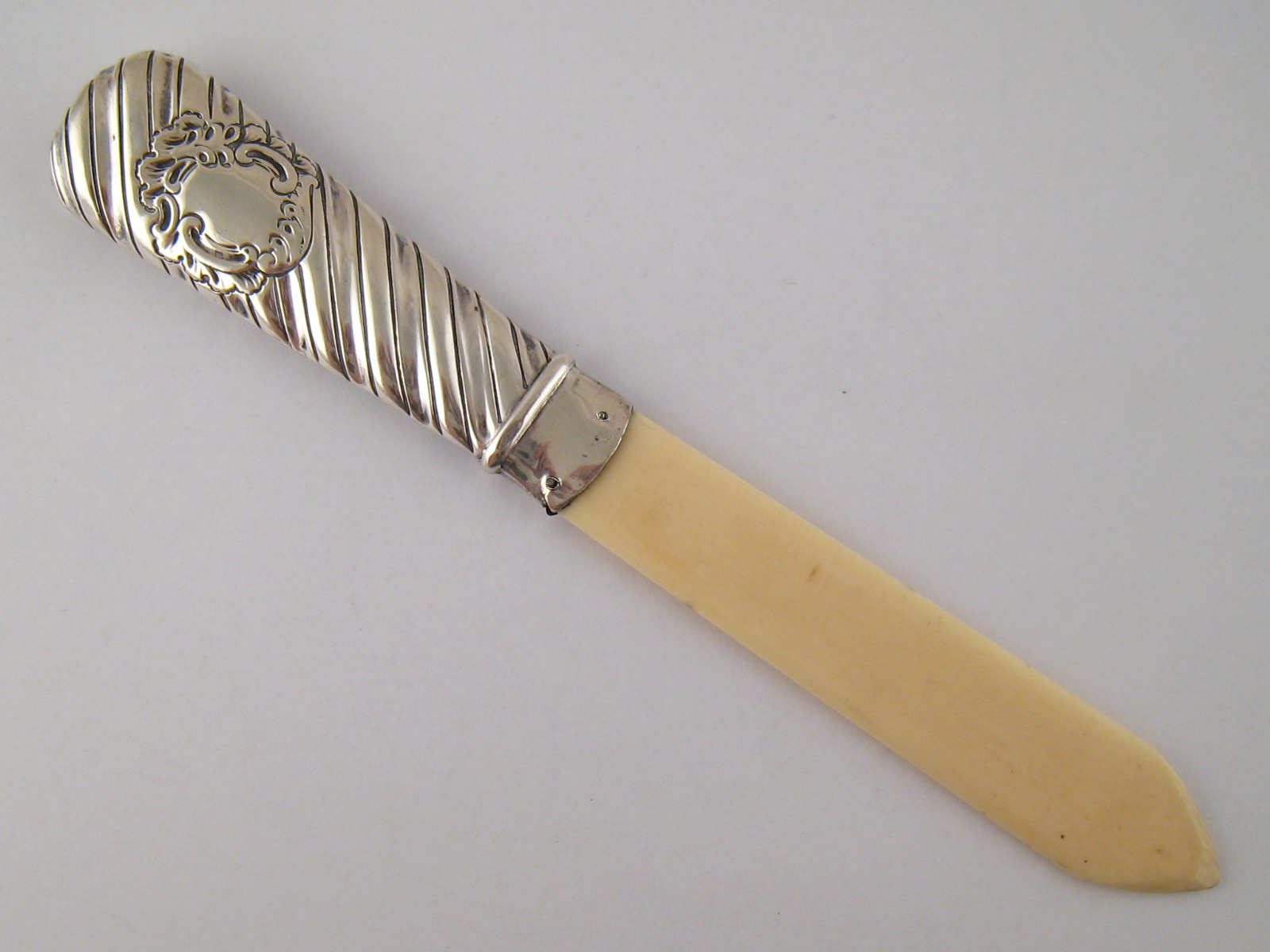 A late Victorian silver handled ivory page turner/ letter opener with gadrooned handle and vacant