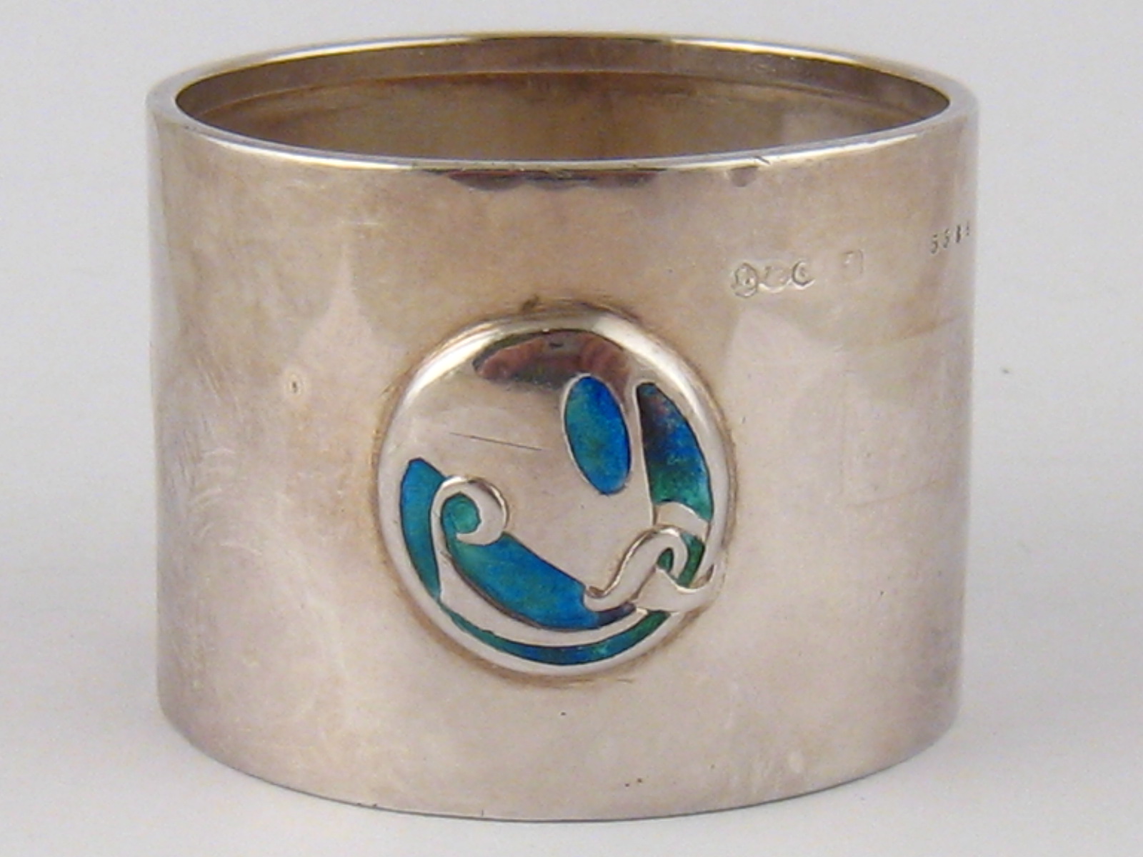 A Liberty &Co. Arts and Crafts silver napkin ring, model no. 5384 with three turquoise enamel