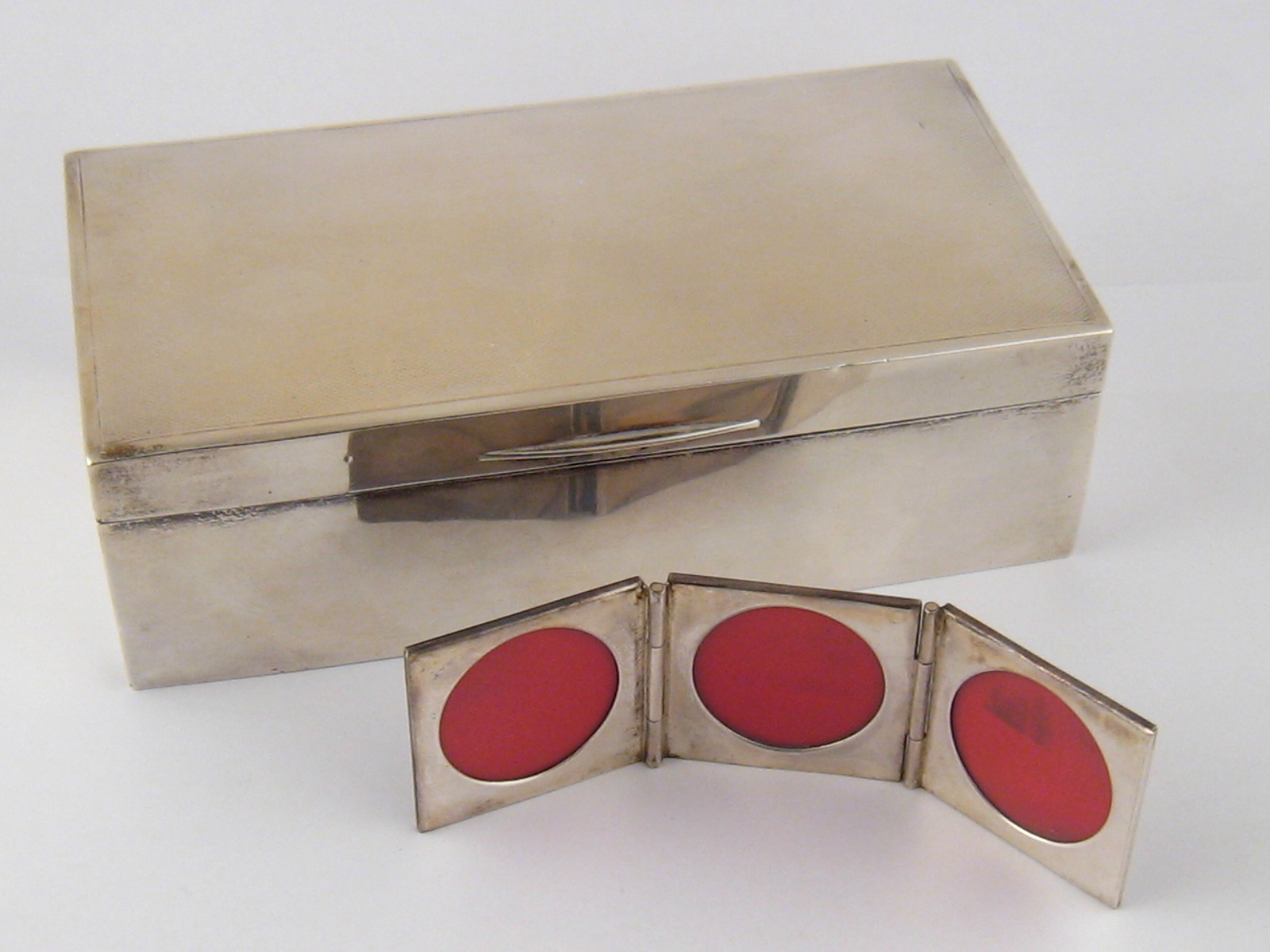 A silver cigarette box with engine turned finish , marks rubbed, 17x9x5cm. , together with a