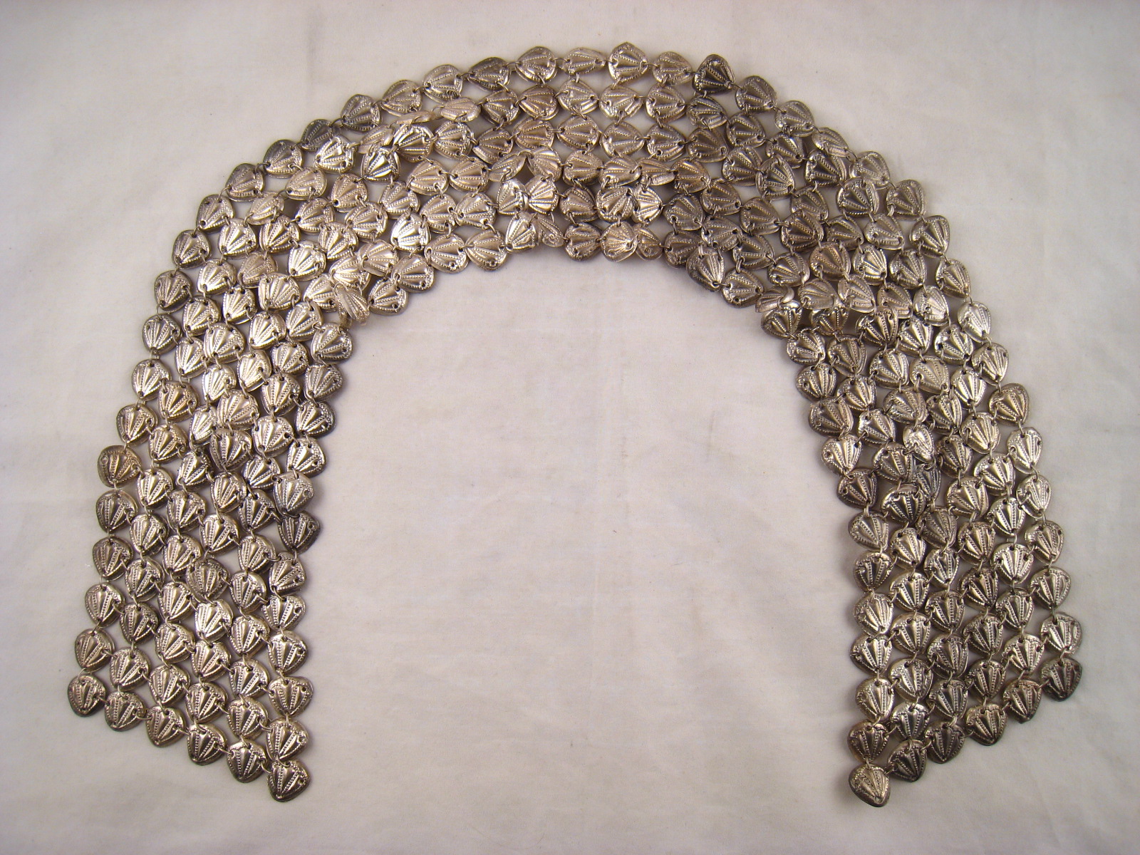 A white metal, untested, long dress ornament , possibly for a tallit, formed as linked shells in six