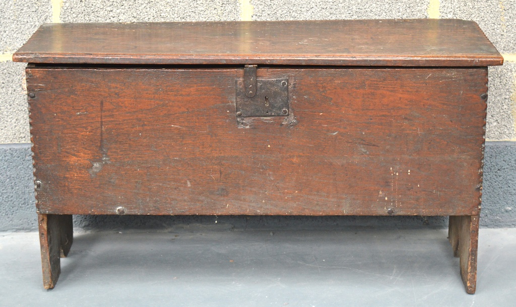 AN EARLY 17TH CENTURY CHARLES I CARVED OAK PLANK CHEST with plain rectangular top rising top. 3ft