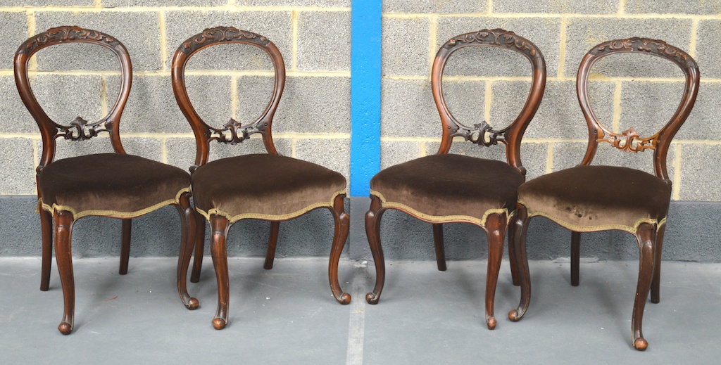 A SET OF FOUR VICTORIAN CARVED WALNUT BALLOON BACK DINING CHAIRS with carved foliate frame and