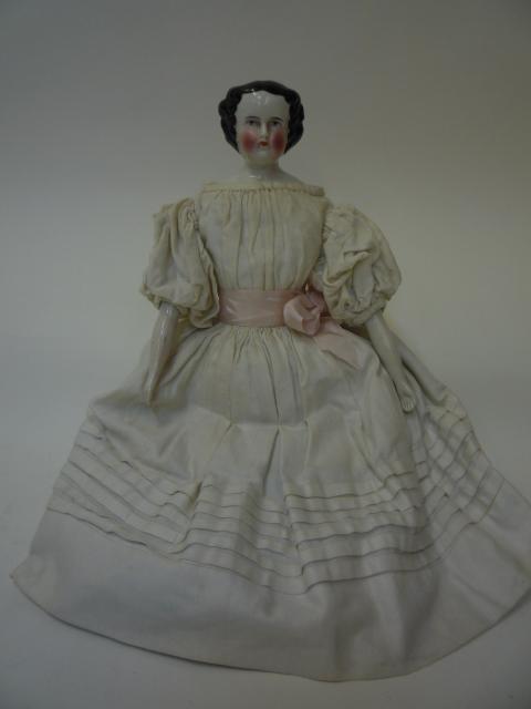 Dolls & Equipment. A German china shoulder head doll with painted face, moulded hair, stuffed fabric