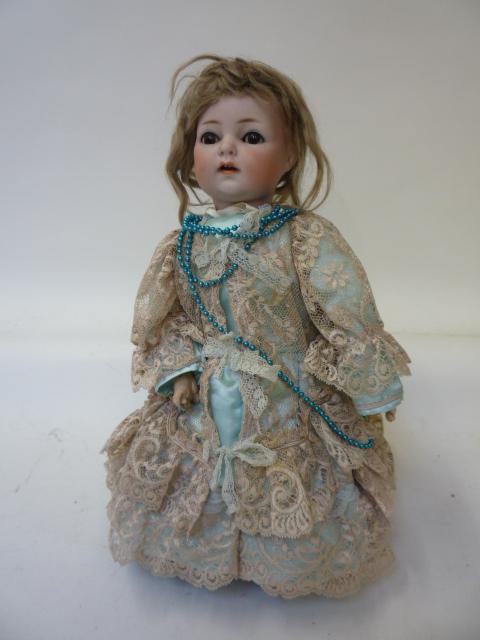 Dolls & Equipment. A Kammer & Reinhardt bisque head girl doll with brown glass sleeping eyes, open