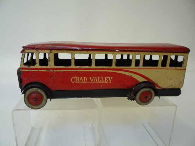 A Chad Valley single decker bus, in red and cream, clockwork motor (AF), 10" long