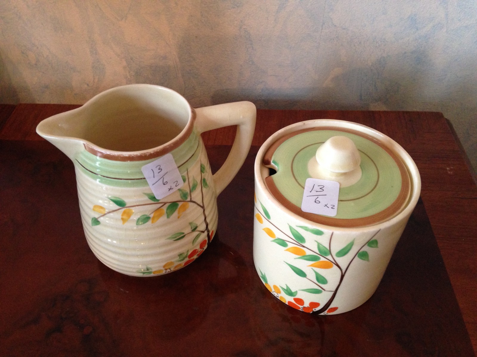 Clarice Cliff pottery milk jug and jam pot.