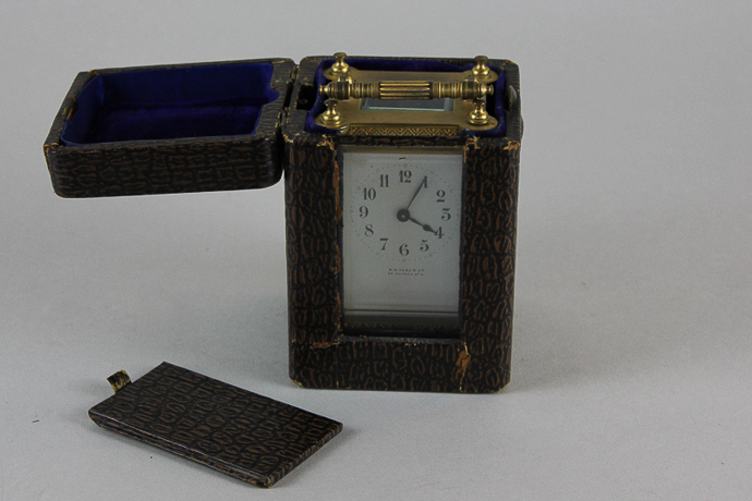 A Victorian brass and glass cased carriage clock with `floral and lattice` decorated case and