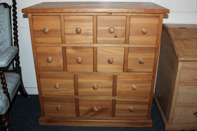 A strip pine chest with an arrangement of fourteen drawers on plinth base, 88cm