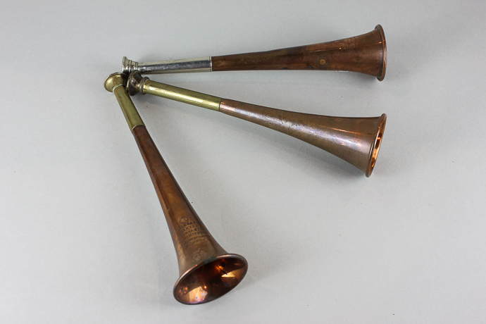 Three copper hunting horns including one by Kohler and Son, 24cm