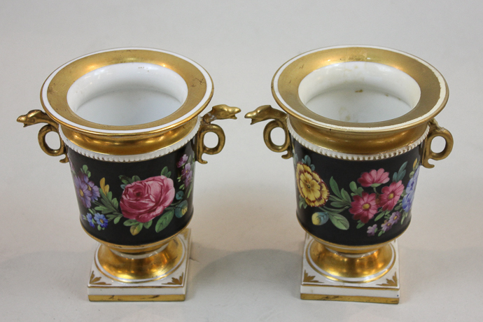 A pair of French porcelain urn shaped vases decorated with bands of bright summer flowers and