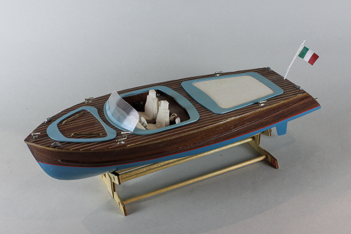 A wooden model `power boat` fitted with radio control no hand set), 42cm long