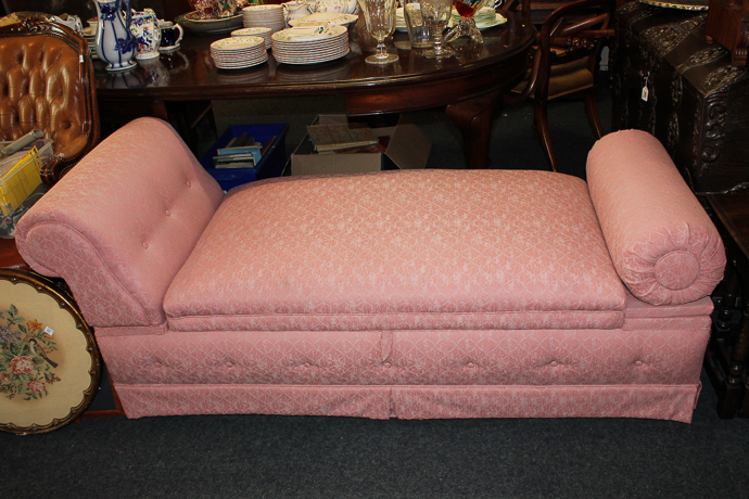 An ottoman/chaise longue with scroll and bolster ends and hinged box seat, with buttoned front,