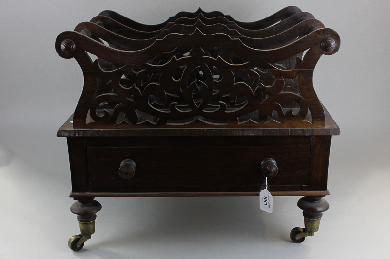 A Victorian rosewood Canterbury with three fretted divisions above drawer on short turned legs