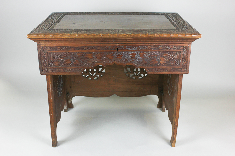 A late 19th century Indian `Kashmiri` small work table with carved edge, lifting top and fitted