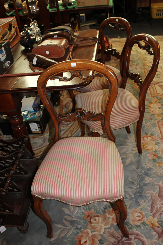 A set of six Victorian dining chairs with spoon shaped backs and serpentine seats on cabriole