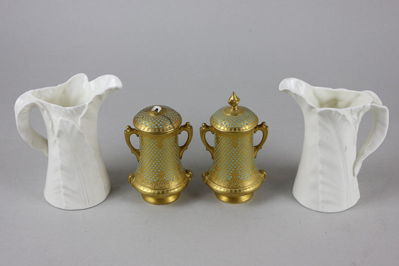 A pair of Royal Worcester white porcelain leaf pattern jugs, together with a pair of gilt and