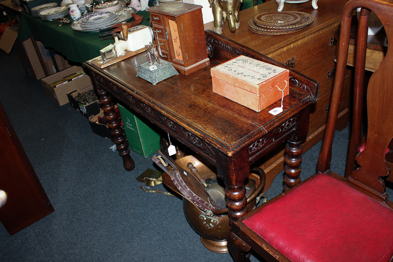 An early 20th century oak side table with raised back and carved frieze, on turned legs, 112cm