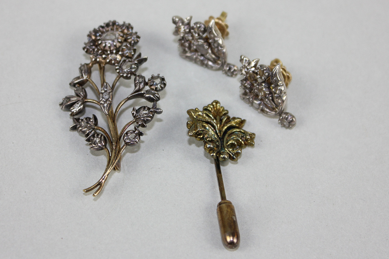 A flower brooch set with rose cut diamonds, a pair of similar earrings for pierced ears and a silver