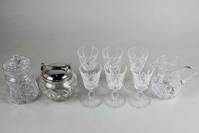 A set of six cut glass sherry glasses, a glass cube sugar jar with patent tongs, a glass jar and a