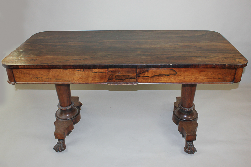 A William IV rosewood library table with rectangular top and two end drawers on twin turned