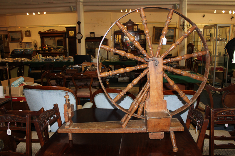 A large 19th century spinning wheel with turned `spokes` on board base with side box having lift-