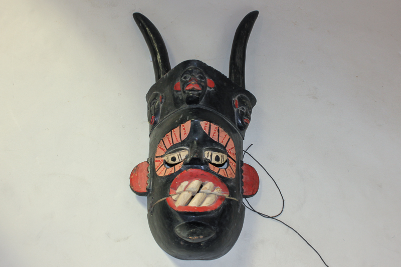 An African witch doctor`s wooden mask with opening mouth and crescents for eyes, with horns, 59cm