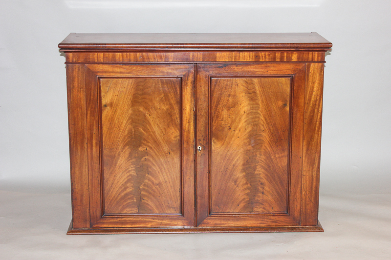 A Victorian dwarf mahogany cupboard enclosed by two panelled doors, 118cm