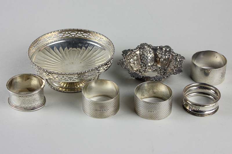 A pair of machine turned silver napkin rings; three other napkin rings and two small silver