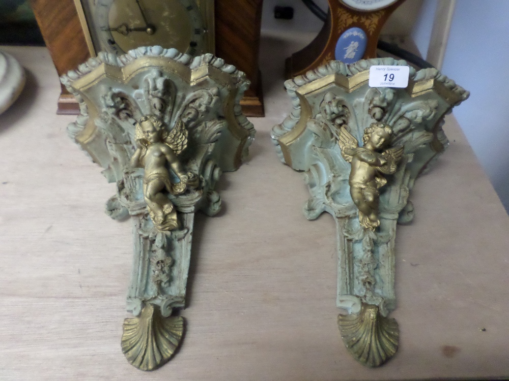 Pair of wall brackets painted in pale blue gold winged