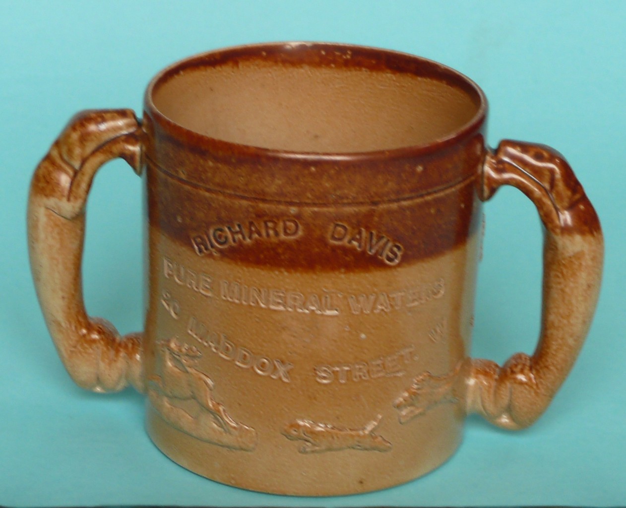 A Fulham Pottery loving cup impressed Richard Davis, Pure Mineral Waters, 20 Maddox Street, 108mm