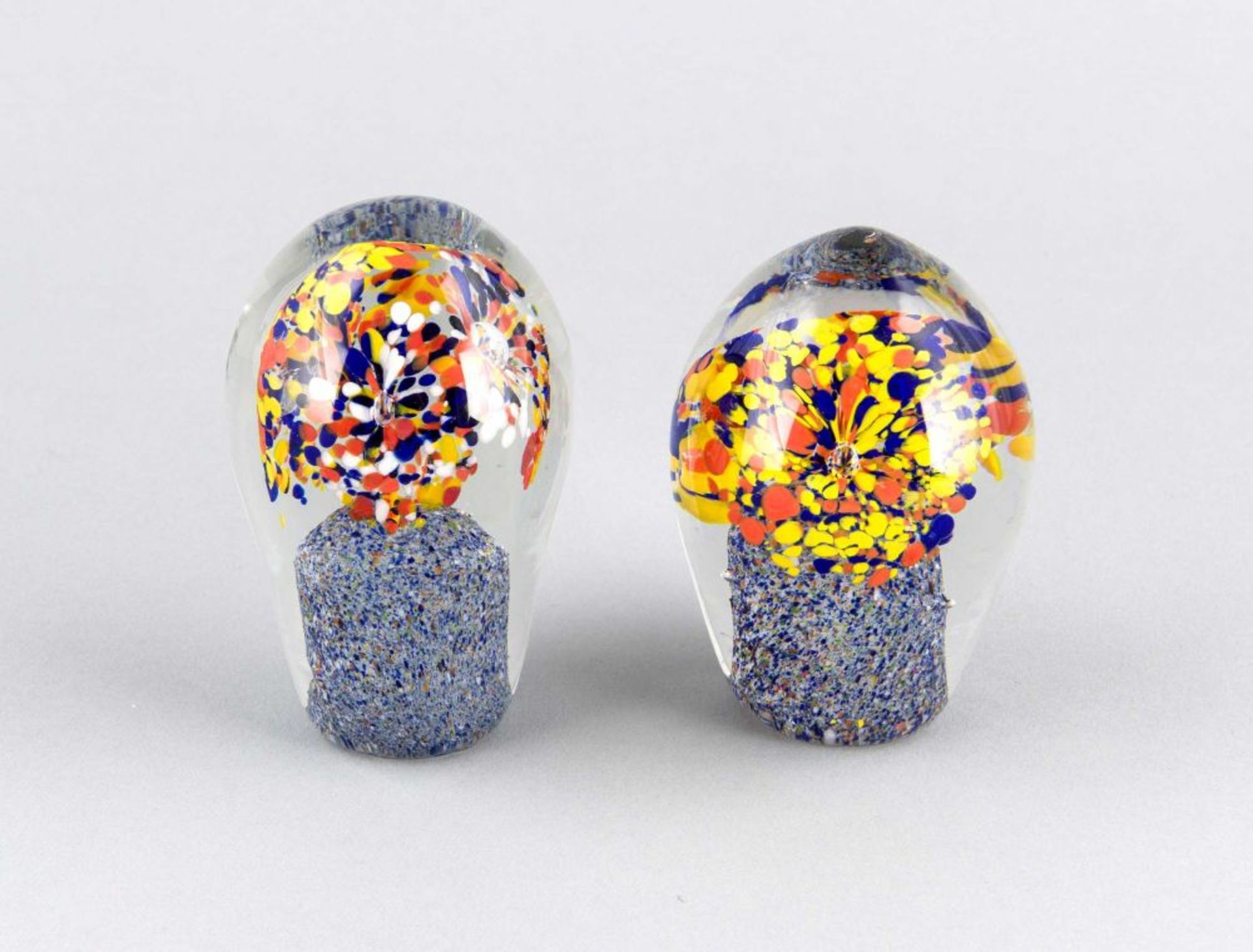 Paar Paperweights, 20. Jh., ovoide Form, klares Glas mit polychromen Fleckeneinschmelzungen in